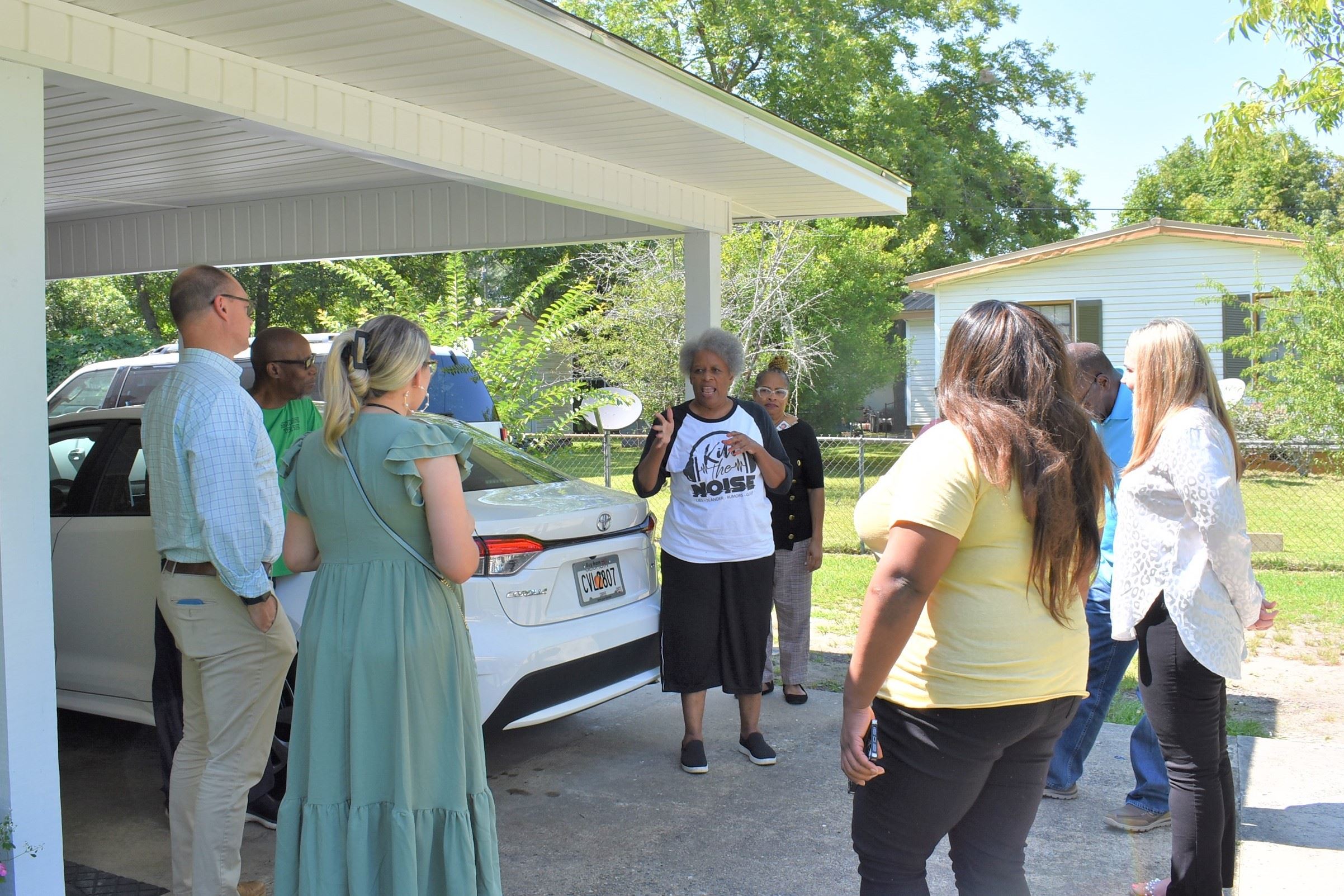 Photo of people talking outside of home about repairs