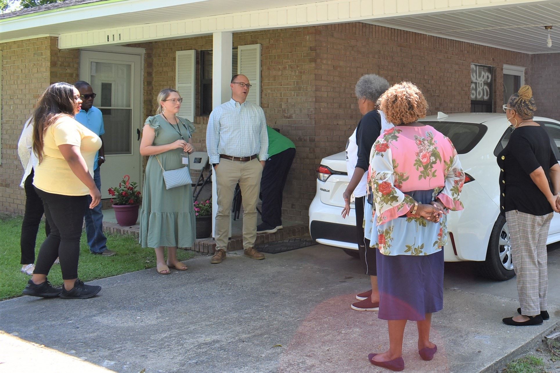 Photo of people talking outside of home about repairs
